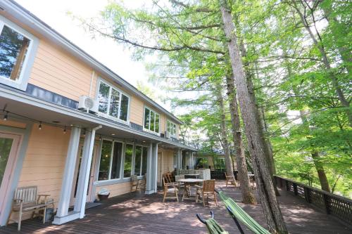 eine Veranda eines Hauses mit einem Tisch und Stühlen in der Unterkunft Ryosha Tsukiakari in Yamanakako