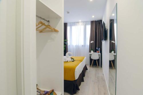 a bedroom with a yellow bed and a mirror at Hotel BESTPRICE Alcalá in Madrid