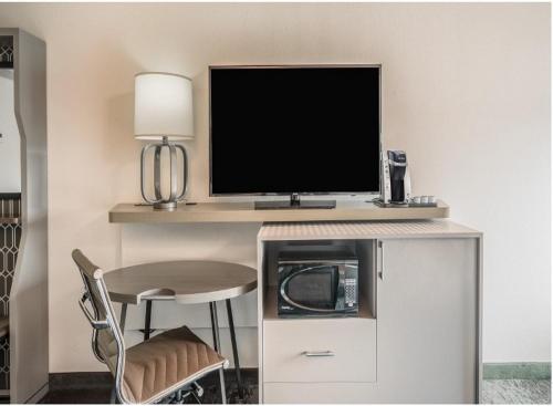 een kamer met een bureau, een tv en een stoel bij Holiday Inn Roanoke Airport - Conference CTR, an IHG Hotel in Roanoke