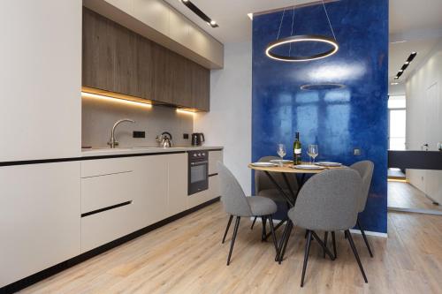 cocina y comedor con mesa y sillas en Level 24 - Sea & Sky View Apartment, en Odessa