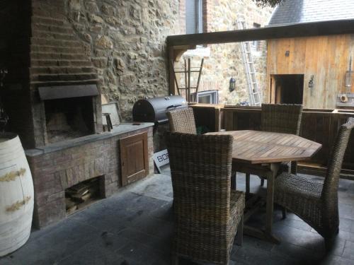 un patio con mesa, sillas y chimenea en Maison Druyard huis met 5 slaapkamers, en Durbuy