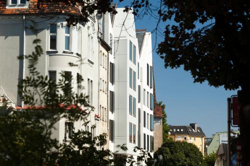 ein hohes weißes Gebäude mit Fenstern auf einer Stadtstraße in der Unterkunft PURO Hotel Poznań Stare Miasto in Posen