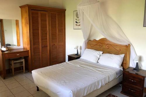 una camera con letto bianco e testiera in legno di Delightful 4bed modern villa with WiFI a Gros Islet