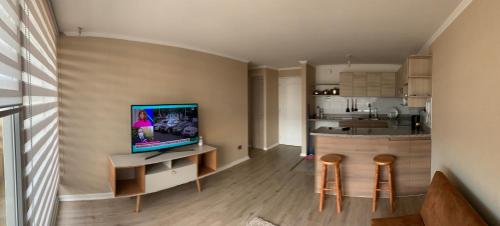 sala de estar con TV y cocina en Acogedor depto en barrio residencial, La Serena, en La Serena