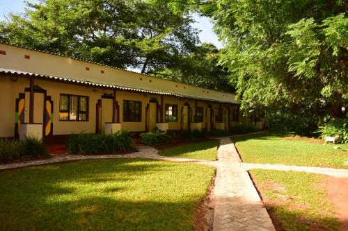 een oud huis met een grasveld en een gebouw bij Shoestrings Backpackers Lodge Vic Falls in Victoria Falls