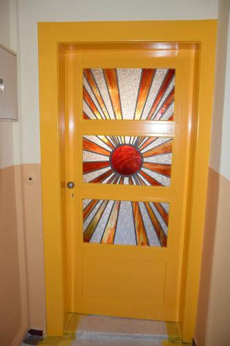 a yellow door with a stained glass window on it at Ferienwohnung Heinrichseck in Bamberg