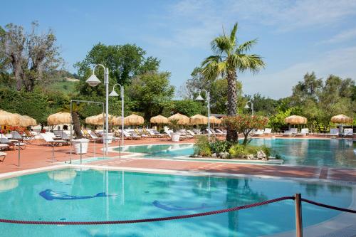 een groot zwembad met stoelen en parasols bij Montespina Park Hotel in Napels