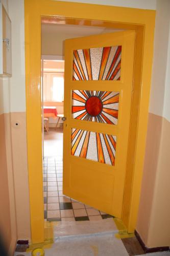 a yellow door with a stained glass window at Ferienwohnung Heinrichseck in Bamberg