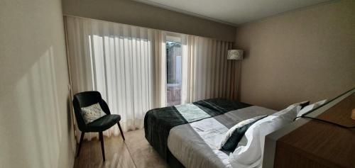 - une chambre avec un lit, une chaise et une fenêtre dans l'établissement Victory Village 16F, à Quinta do Lago