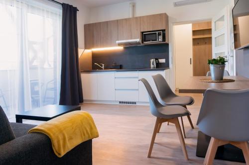 salon z kanapą i krzesłami oraz kuchnię w obiekcie Wellness Apartmány Panorama w mieście Luhačovice