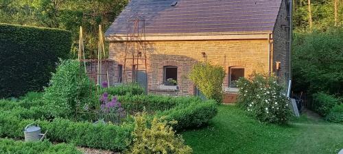 une petite maison en briques avec un jardin en face de celle-ci dans l'établissement La Faironnière, à Hamoir