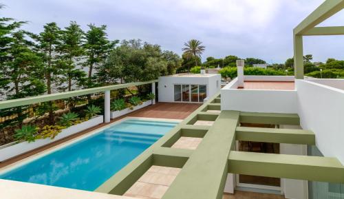 een huis met een zwembad en een balkon bij Villa Santandria Grupo Seranova Luxury Hotel in Ciutadella