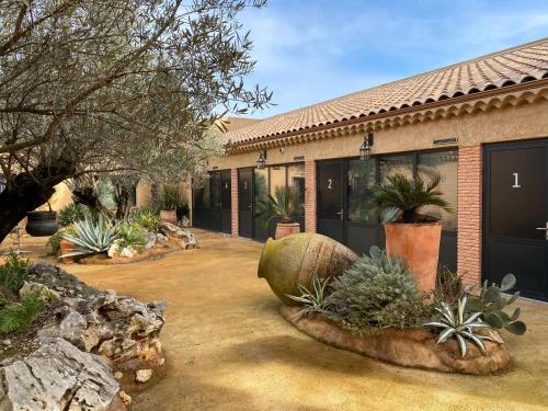 una casa con muchas plantas en el patio en HOTEL NATURE LE LOFT, en Pierrelatte