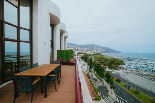 balcone con tavoli, sedie e vista sulla città di Rooftop Marina l by Madeira Best Apartments a Funchal