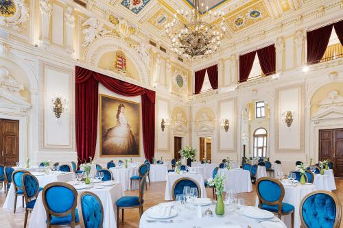 een eetkamer met witte tafels en blauwe stoelen bij Áurea Ana Palace by Eurostars Hotel Company in Boedapest