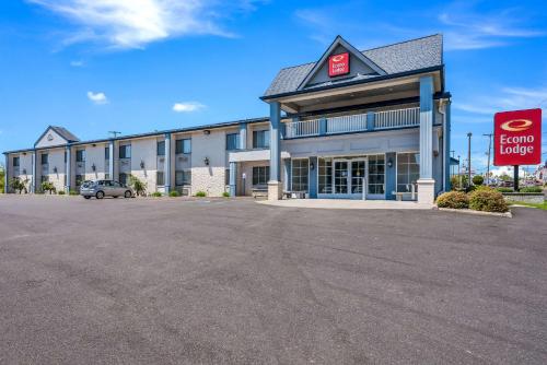 un gran edificio con un letrero de alquiler en un estacionamiento en Econo Lodge Quakertown, en Quakertown