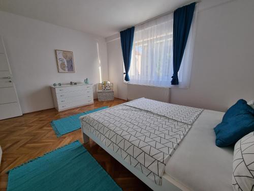 1 dormitorio con 1 cama y una ventana con alfombras azules en Apartman Nataly, en Varaždin