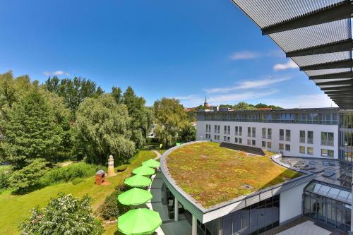 budynek z zielonym dachem z parasolami w obiekcie Parkhotel Rügen w mieście Bergen auf Rügen