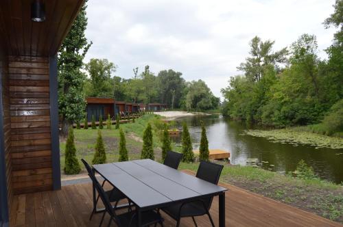 una mesa y sillas en una terraza junto a un río en Fisherman, en Kiev