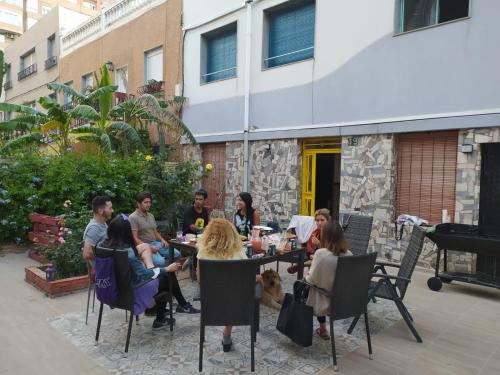 un gruppo di persone seduti intorno a un tavolo in un patio di LA PITA BEACH HOUSE a Almería