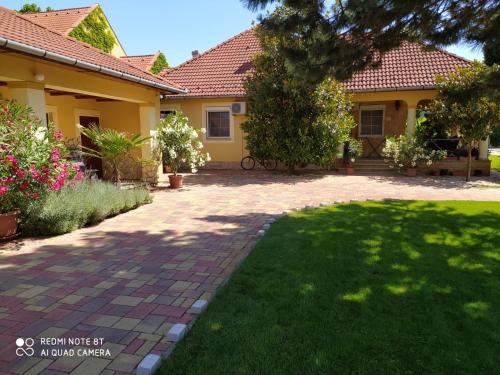 ein Haus mit einem gemauerten Gehweg vor einem Hof in der Unterkunft Spengler Apartman in Harkány