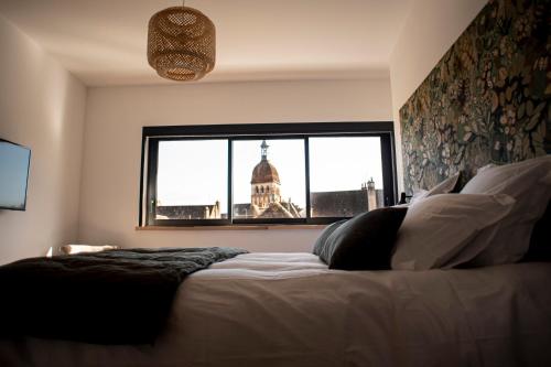 A bed or beds in a room at Les Terrasses de Notre Dame