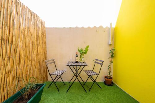 una mesa y sillas en un patio con una valla en Chez Emile Le Jaune Vendée - T2 renové - Terrasse, en Niort