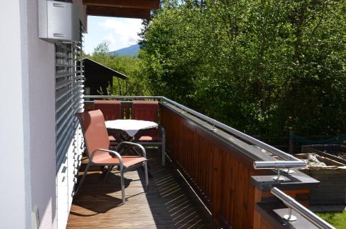 um pátio com uma mesa e cadeiras num deque em Appartement Nischler em Wald im Pinzgau