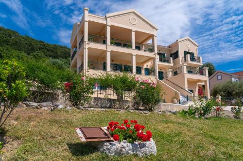 a house on a hill with flowers in front of it at Maria's Apartments in Sami