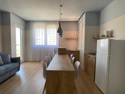 a kitchen with a long table and a refrigerator at PROMO PRICE - Colorful by the sea - 1 min from the beach in Durrës