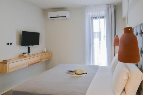 una camera con un letto con un cappello e una TV di Princess Mare Hotel - Adults Only a Naxos Chora