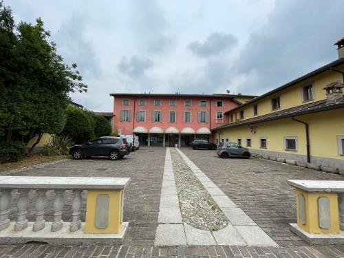 ein großes rotes Gebäude mit Autos auf einem Parkplatz in der Unterkunft Bes Hotel Bergamo Cologno al Serio in Cologno al Serio