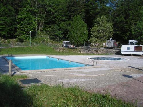 een zwembad in een tuin met een camper geparkeerd bij Camping Pivka Jama Postojna in Postojna