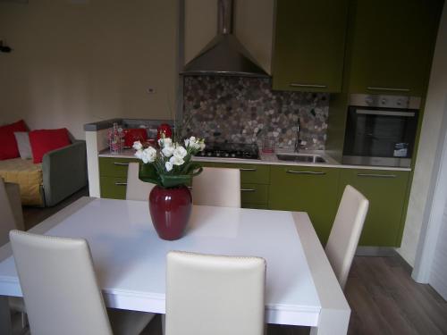 una cocina con una mesa blanca con un jarrón de flores. en Casa Molinari, en Como