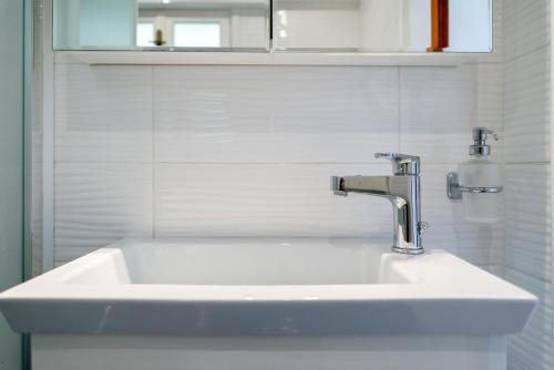 lavabo blanco en el baño con espejo en Europe Hotel, en Argostoli