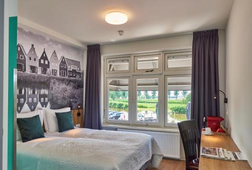 een slaapkamer met een bed en een groot raam bij Hotel VILLA GROET in Avenhorn