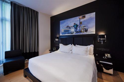 - une chambre avec un grand lit blanc et un mur noir dans l'établissement YOOMA Urban Lodge, à Bruxelles