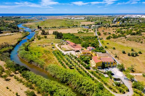 an aerial view of a house next to a river at Quinta Almargem Lusitano - Farm House in Tavira