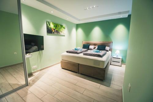 a bedroom with a bed in a room with green walls at The Place Apartments Hebrangova in Zagreb