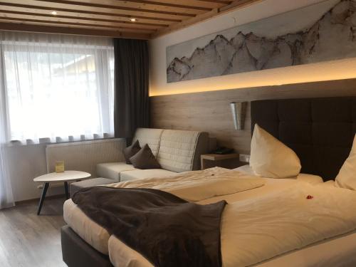 a hotel room with two beds and a couch at Landhotel Kaserer in Bramberg am Wildkogel