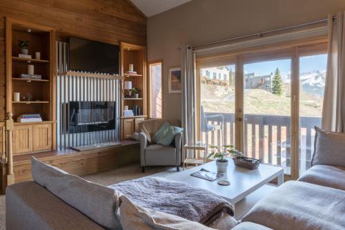 sala de estar con sofá, mesa y TV en SKI IN, WALK OUT! The perfect mountain retreat!, en Crested Butte