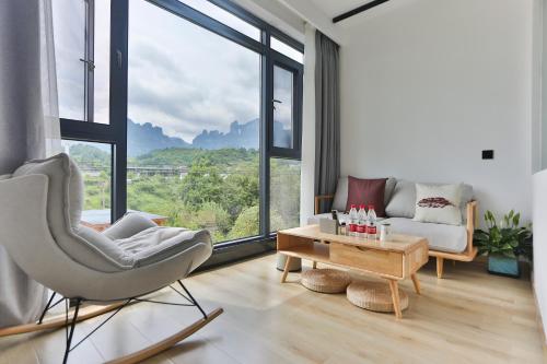 a living room with a chair and a couch and a table at Heaven's Gate Home Stay in Zhangjiajie