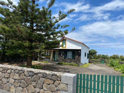 una casa con una pared de piedra y una valla en Casa da Costa, en Madalena