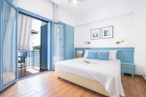 - une chambre avec un grand lit et un balcon dans l'établissement Saronis Hotel Agistri - Adults Only, à Skala