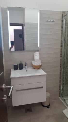 bagno con lavandino bianco e specchio di AURA Residence a Rovigno (Rovinj)