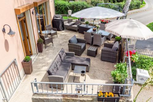 an overhead view of a patio with couches and an umbrella at ElbPension & Ferienwohnung Sächsische Schweiz in Pirna