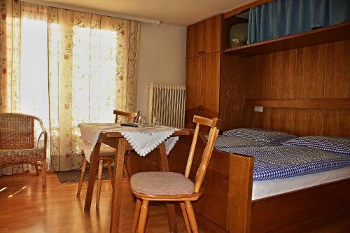 - une chambre avec un lit, une table et des chaises dans l'établissement Pension Alpentraum, à Zell am See