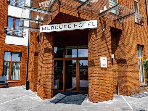 WiązownaにあるMercure Wiazowna Brantのレンガ造りの建物の横方のアロベホテルサイン