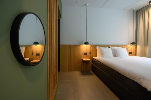 een slaapkamer met een groot bed en een spiegel bij Hotel & Wellness Zuiver in Amsterdam