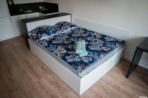 a bed in a room with a blue and white blanket at Wyszyńskiego 10 in Białystok